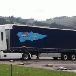 Camión con remolque azul y logotipo aparcado