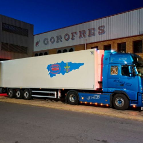 Camión azul con remolque blanco aparcado y realizando carga