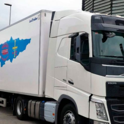 Camión blanco con logotipo sobre mapa de Asturias en primer plano